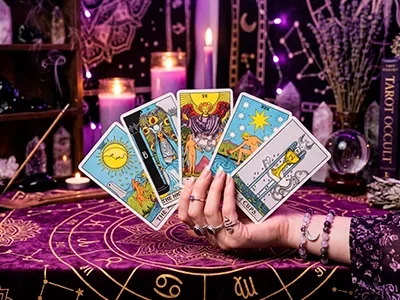 Cartas de tarot dispuestas frente a bola de cristal y cuarzos